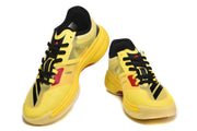 Yellow basketball shoes shown from above, highlighting black laces and red accents