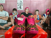 Front view of Nike basketball sneakers with a vivid multicolor patterned upper, pink laces, and purple soles.