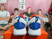 Rear view showing blue heel panels and orange Nike logos on white Nike Zoom shoes