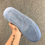 Underside view of the sneaker showing a translucent blue outsole with circular and linear tread patterns.