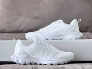 Pair of white Alo sneakers photographed from the side.
