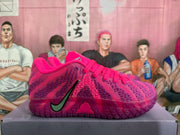 Side profile of a pink Nike basketball sneaker showing the Swoosh, patterned upper, translucent outsole, and Zoom branding.