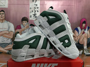 Pair of white and dark green Nike sneakers shown from an angled side view on a red shoebox.