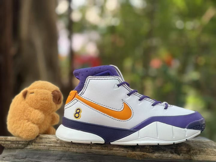 Side view of a white high-top kids' basketball shoe with purple trim, orange swoosh and number 8 detail.