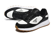 Angled view of black and white lace-up sneakers with triangular side plaques.