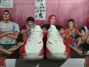 Front view of red and white Nike basketball sneakers with white laces, white toe panels, and red accents.