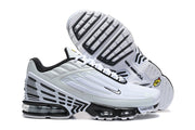 Side and outsole views of a white and black Nike sneaker.