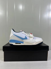 Side profile of the white and blue low-top sneaker with patterned heel panel and visible midsole air window.