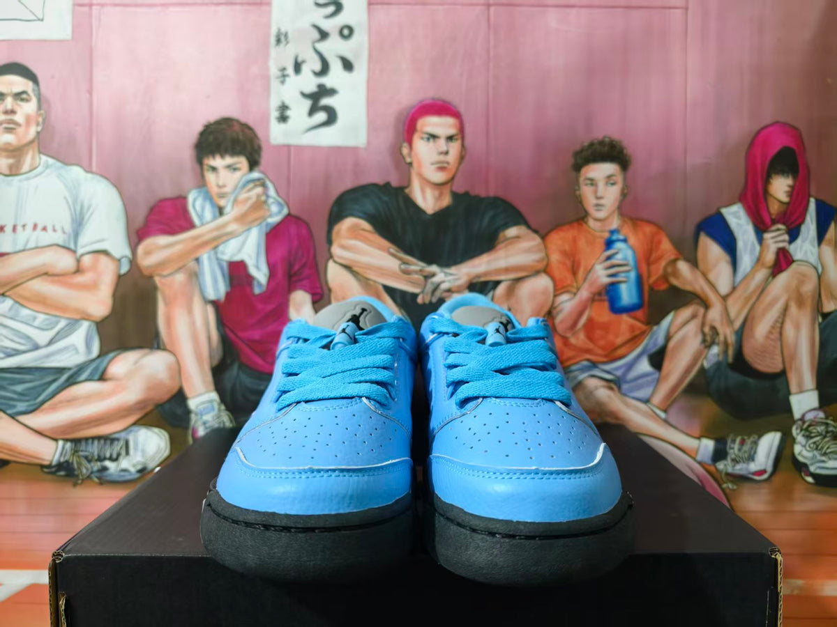 Front view of blue low-top sneakers with matching laces, perforated toe boxes, black midsoles, and light-colored outsoles.