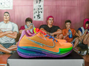 Side view of orange basketball shoe with silver-toned side detail and blue laces