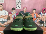 Front view of green basketball sneakers showing mesh uppers, patterned tongue straps, and lime-green outsoles.