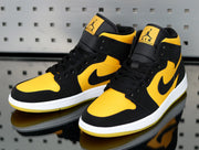 Pair of yellow and black Jordan high-top sneakers shown from a front three-quarter angle with white midsoles and yellow outsoles.