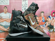 Angled view of the pair showing multicolor forefoot panels, black patterned ankle sections, white side branding, and white outsoles.