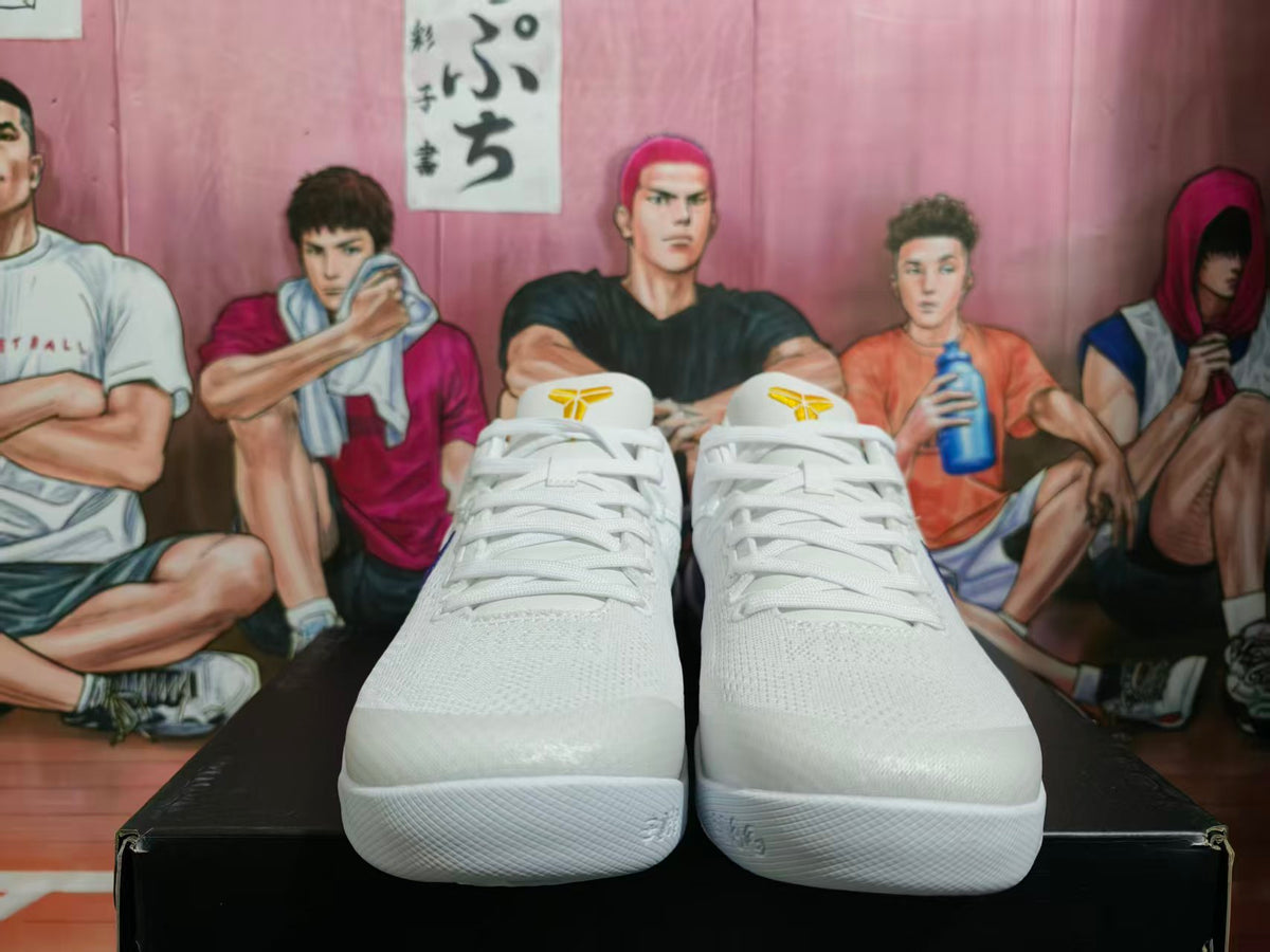 Pair of white Nike basketball sneakers shown from the front with white laces and yellow tongue accents.