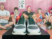 Front view showing the white and gray perforated toe boxes, dark green laces, and basketball-style low-top construction.