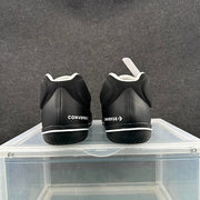 Rear view of a pair of black sneakers with Converse branding on the heels.