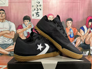 Pair of black low-top sneakers with white side emblems and gum-colored outsoles