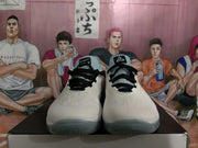 Front view of white Nike basketball sneakers with black laces, turquoise tongues, and translucent gray outsoles.