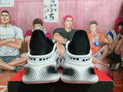 Rear view of the sneakers showing black padded heel collars, white heel sections, and the black-and-white dotted midsole pattern.