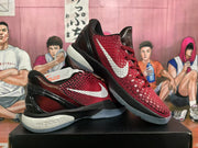 Angled view of the paired black and red Nike LeBron sneakers showing the white Swoosh, red textured panels, and translucent outsole.