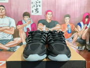 Pair of black Nike basketball sneakers shown from the front on a shoebox, with mesh uppers and translucent white outsoles.