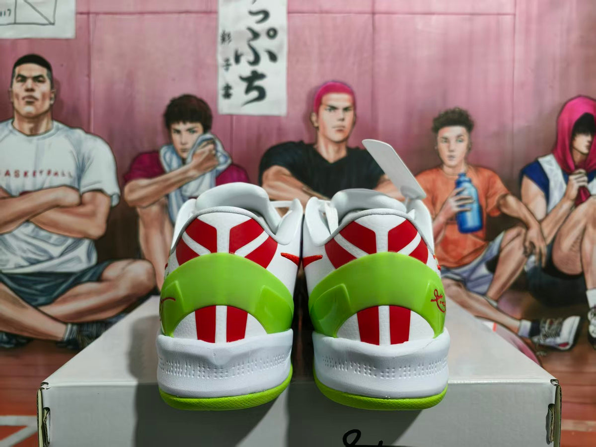 Rear view of the colorful Nike basketball sneakers showing white uppers, bright green heel sections, red accents, and green outsoles on a shoebox.