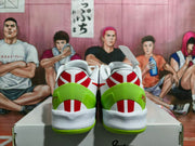 Rear view of the colorful Nike basketball sneakers showing white uppers, bright green heel sections, red accents, and green outsoles on a shoebox.