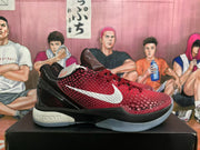 Side profile of a red and black Nike LeBron sneaker with a white Swoosh, textured upper, glossy heel, and visible midsole branding.