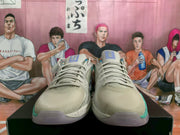 Front view of the pair showing beige toe boxes, gray laces, textured panels, and teal outsole accents.
