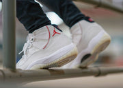 Worn side view showing the white upper, red trim, and translucent outsole.