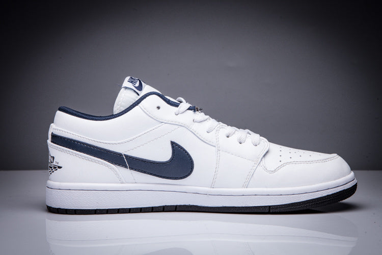 Side view of a white low-top Jordan sneaker with a dark Swoosh and rubber outsole.