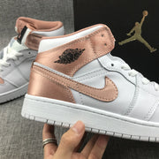 Close-up of the rose-gold ankle panel, winged basketball logo, Swoosh, and stitching.