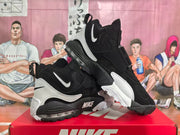 Pair of black and white Nike high-top sneakers displayed on a red Nike shoebox.