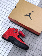 Red and black Jordan sneaker beside a Jordan shoebox and an additional red lace set.