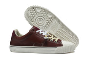 Burgundy sneaker beside its patterned white outsole