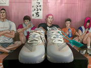 Front view of adidas basketball shoes with white laces and a gray, pale blue, and pink upper.
