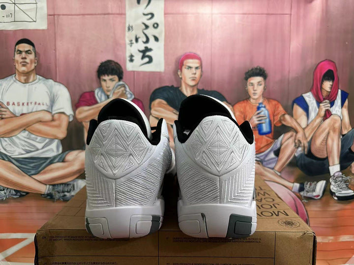 Rear view of white basketball shoes with patterned heel panels, black lining, and dark outsole accents.