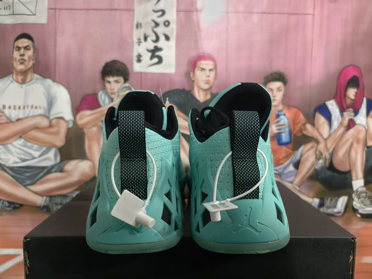 Rear view of green Jordan basketball sneakers with black heel pull tabs and black collar details, displayed on a box.