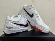 Pair of white Kobe basketball shoes with dark red-edged Swooshes and red outsole accents