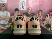 Rear view of the pink Nike basketball sneakers showing black-and-white heel detailing and the light-colored outsole.
