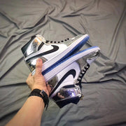 Pair of sneakers held together to show their silver side panels, black Swooshes, and blue outsoles.