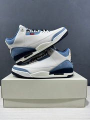 Angled side view of the pair highlighting the layered white, blue, and dark navy construction.