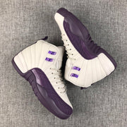 Pair of off-white and deep purple Air Jordan 12 high-top sneakers on a gray fabric surface