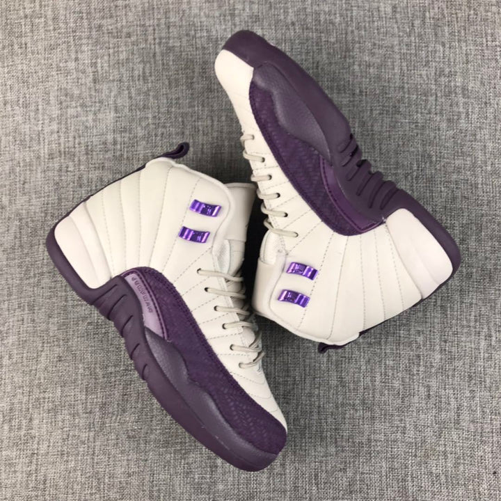 Pair of off-white and deep purple Air Jordan 12 high-top sneakers on a gray fabric surface
