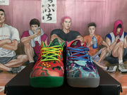 Front view of the mismatched sneakers, showing different patterned uppers, colorful laces, and contrasting green and gray outsoles.
