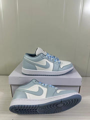 Angled side view showing the stitched side panels, white midsoles, and blue-grey outsoles.