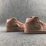 Side profile of a pair of pink and olive Jordan sneakers showing the mid-top collars and outsoles.