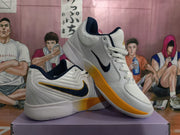 Angled view showing the white textured uppers, navy Nike side detailing, orange outsole sections, and padded collars.