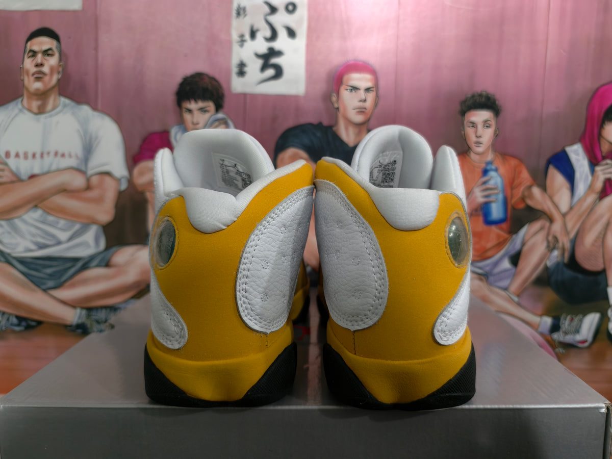Rear view of white and yellow Jordan high-top sneakers with black outsole accents