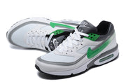 Pair of white and green low-top sneakers shown at an angle.